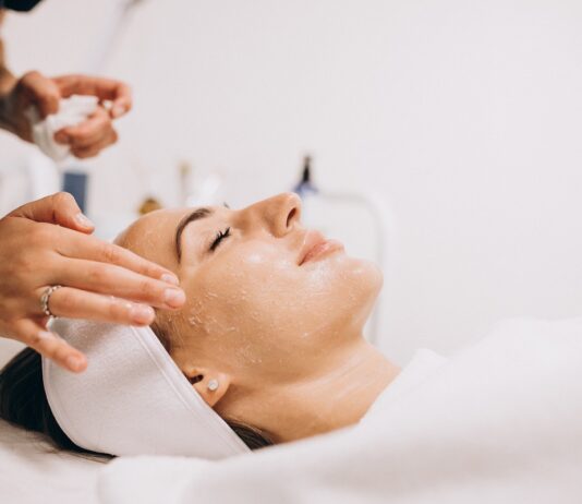 Cosmetologist applying product on woman’s face