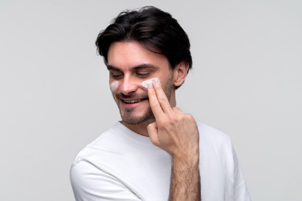 Man applying face cream while smiling