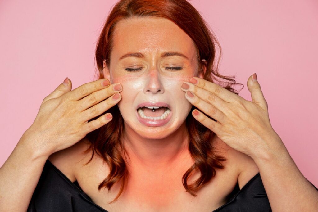 Woman upset about face tan with her hands on her face