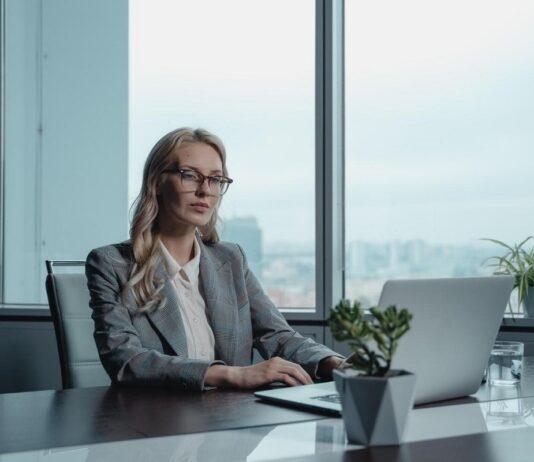 Sharply dressed real estate investor using her laptop to explore business opportunities